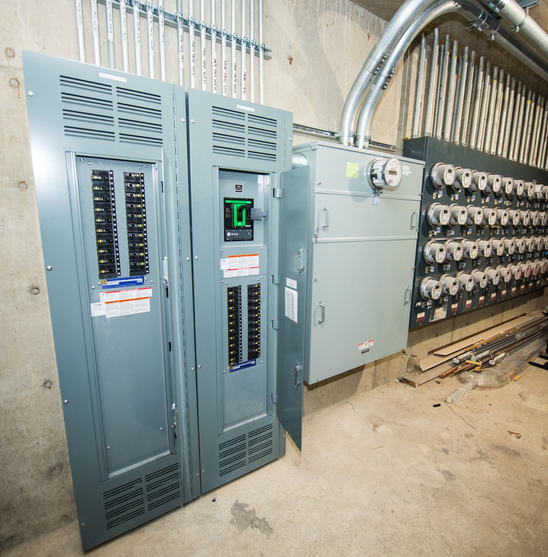 A building electrical room with panels and a bank of resident meters