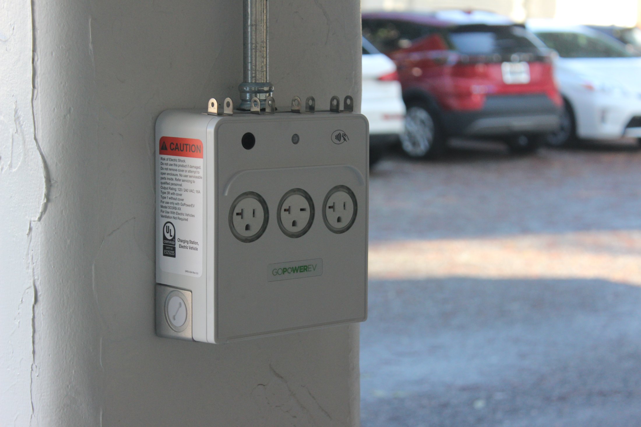 A GoPower PowerPort3 mounted on a parking-structure column with cars parked behind